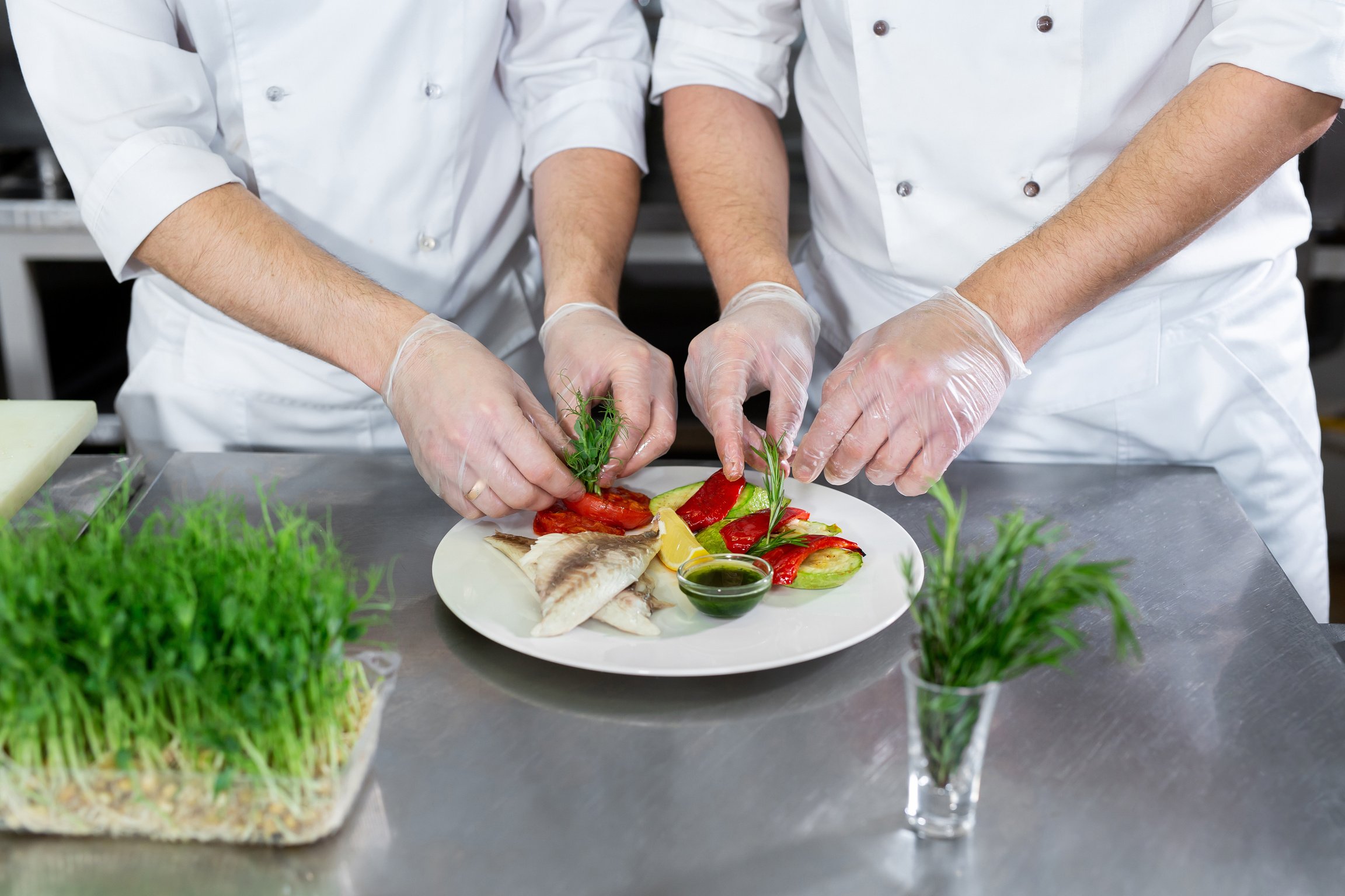 Chef Decorates Fish from Microgreens with Vegetables in the Kitchen